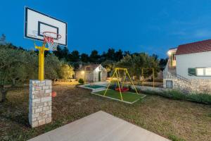 un panier de basket dans une cour avec une maison dans l'établissement Family friendly house with a swimming pool Vela Luka, Korcula - 23698, à Vela Luka