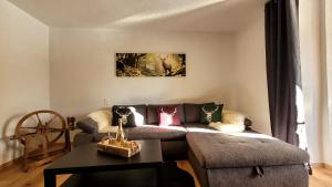 een woonkamer met een bank en een tafel bij FeWo's und Apartment's Blaues Haus in Davos