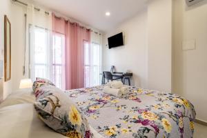 - une chambre avec un lit et une couverture fleurie dans l'établissement Casa Girassol - Lagos, à Lagos