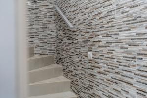 La salle de bains est pourvue d'un mur en briques et d'escaliers. dans l'établissement Casa Girassol - Lagos, à Lagos 11 autres photos