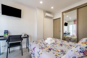 une chambre avec un lit, une table et un miroir dans l'établissement Casa Girassol - Lagos, à Lagos