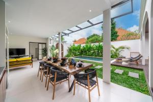 a dining room with a table and chairs in a house at Brand New 4BDR Villa - Cozy and Stylish - CANGGU with Breathtaking Stunning View in Seminyak