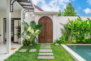a house with a wooden door and a swimming pool at Brand New 4BDR Villa - Cozy and Stylish - CANGGU with Breathtaking Stunning View in Seminyak