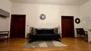 a living room with a black couch and two doors at Casa del Conte in Canino
