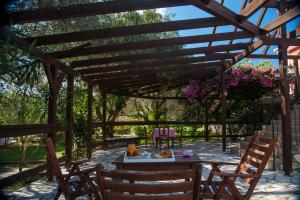 a wooden pergola with a table and chairs at Leventis Villas Complex with Sharing Pool in Spartià