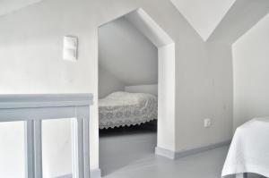 a white room with a bed and a desk at Camara Homes in Andros