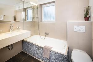 a bathroom with a shower and a sink and a toilet at Hotel Jägerhof und Jagdhaus in Mayrhofen