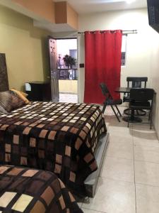 a bedroom with a bed and a red curtain at hotel angeles in San Luis Río Colorado