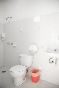 a white bathroom with a toilet and a sink at Hotel Palmarito in Puerto Escondido +49 photos