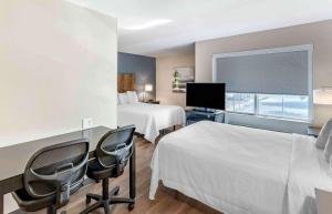 a hotel room with two beds and a flat screen tv at Extended Stay America Premier Suites - San Jose - Airport in San Jose +42 photos