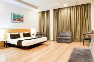 a hotel room with a bed and a chair at Super Townhouse Gomti Nagar Matiyari in Lucknow