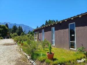 a house with plants in front of it at Entre Pueblos in Lago Puelo +8 photos