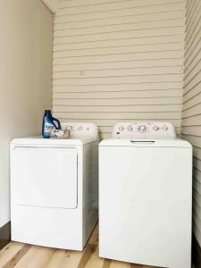 zwei weiße Waschmaschinen nebeneinander in der Unterkunft House of Color EVV Stylish Apartments in Evansville