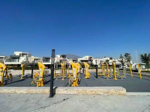 a row of yellow equipment in a parking lot at Casa súper Equipada Cumbres Dominio in Monterrey