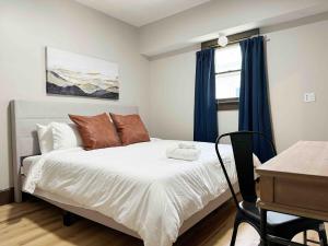 ein Schlafzimmer mit Bett, Schreibtisch und Fenster in der Unterkunft House of Color EVV Stylish Apartments in Evansville