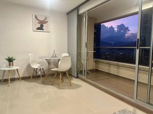 una sala da pranzo con tavolo, sedie e una finestra di Moderno Apartamento Sabaneta- Century Tower II a Envigado