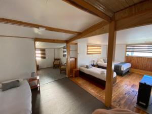a large room with two beds and a desk at Hostal Amerindia in Puerto Natales