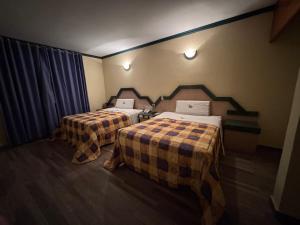 a room with two beds in a room at Motel El Peñon in Navojoa