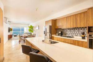 a kitchen with wooden cabinets and a counter top at Wake Up to Paradise – Stunning 2BR Condo Right on the Beach in Puerto Vallarta