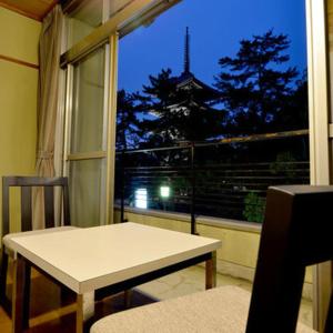 a room with a table and a window with a view at Daibutsukan in Nara