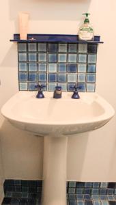 a bathroom sink with a blue tile shelf above it at Sandy Swell Beach Shack - Goolwa in Goolwa South