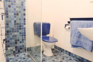 a bathroom with a blue toilet and a sink at Sandy Swell Beach Shack - Goolwa in Goolwa South +17 photos