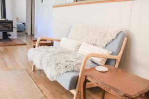 a living room with a chair and a table at Sandy Swell Beach Shack - Goolwa in Goolwa South