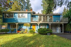 a blue house with a balcony and a yard at NorthVAN nature living home in North Vancouver