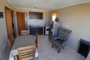 eine Küche und ein Esszimmer mit einem Tisch und einem Kühlschrank in der Unterkunft Alquiler por día Gobernador Gregores in Gobernador Gregores