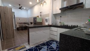 a kitchen with black and white counter tops at Alam Perdana @ Kemaman Cukai in Cukai