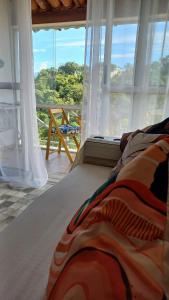un letto in una camera con una grande finestra di Casa inteira na PRAIA & SERRA Melhor Resort Angra a Conquista Altre 50 foto