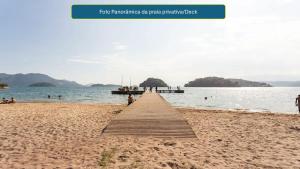 un molo in legno su una spiaggia accanto all'acqua di Casa inteira na PRAIA & SERRA Melhor Resort Angra a Conquista
