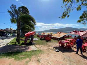 a group of tables and chairs with umbrellas on a street at Imana Hostel in Florianópolis