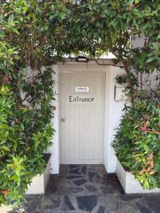 a white garage door with the word entrance on it at Mem Homestay in Ban Khlong Wang Chang