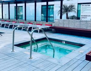 Una piscina con mesas y sillas en un edificio. en Hollywood Retreat One Bedroom - Walk to Walk of Fame Free Parking Pool & Gym, en Los Ángeles