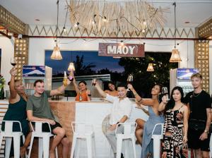 a group of people sitting at a bar with their hands up at On Board Lifestyle Resort FREE MOTORBIKE in Bil-isan +91 photos