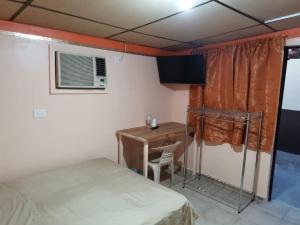 ein Zimmer mit einem Bett, einem Schreibtisch und einem Tisch in der Unterkunft Departamento Doki in Hermosillo