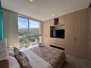 a bedroom with a bed and a large window at Edificio Salguero Suites in Santa Marta
