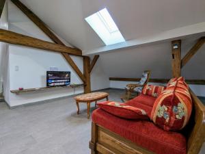 a living room with a red couch and a tv at Appartement cosy, 2 chambres et parking privé, proche des Vosges - FR-1-589-780 in Saint-Michel-sur-Meurthe