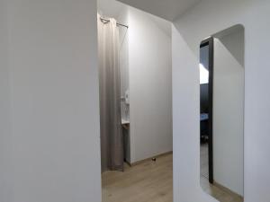 a hallway with white walls and a mirror at Appartement cosy, 2 chambres et parking privé, proche des Vosges - FR-1-589-780 in Saint-Michel-sur-Meurthe