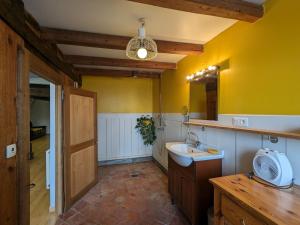 ein Badezimmer mit einem Waschbecken und einer gelben Wand in der Unterkunft Gîte rénové à Mauvages avec jardin, BBQ et WIFI - FR-1-585-167 in Mauvages + 28 Fotos