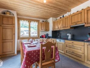 a kitchen with wooden cabinets and a table with a table cloth at Chalet cosy aux Gets avec parking privatif - FR-1-671-279 in Les Gets