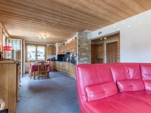 a living room with a red couch and a kitchen at Chalet cosy aux Gets avec parking privatif - FR-1-671-279 in Les Gets