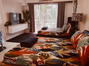 a living room with two beds with a colorful blanket at 215 Carola B - Pico de Loro in Cutad