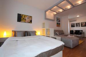 um quarto com uma grande cama branca e um sofá em New Belgrade apartment Neven, parking 5 evra dan em Belgrado