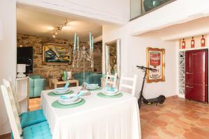 un comedor con una mesa blanca y sillas azules en Steps from the Port! Chic 2-Bed in the Heart of Saint-Tropez, en Saint-Tropez