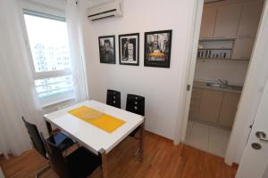 uma cozinha com uma mesa e cadeiras brancas e uma janela em New Belgrade apartment Neven, parking 5 evra dan em Belgrado