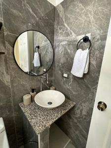 un baño con lavabo y espejo en Casa Bonita, en San Miguel