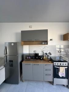 Una cocina con refrigerador de acero inoxidable y estufa. en Casa Bonita, en San Miguel