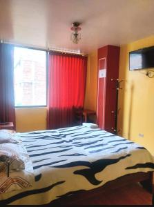 a bedroom with a large bed and a window at Hotel Valle de Guano in Guano